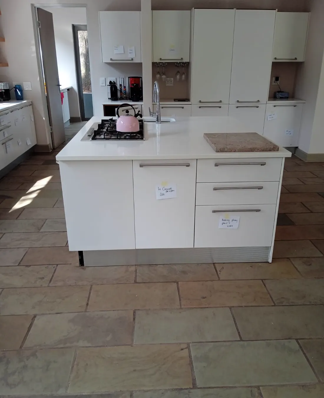 Complete residential kitchen renovation with island and white cabinetry