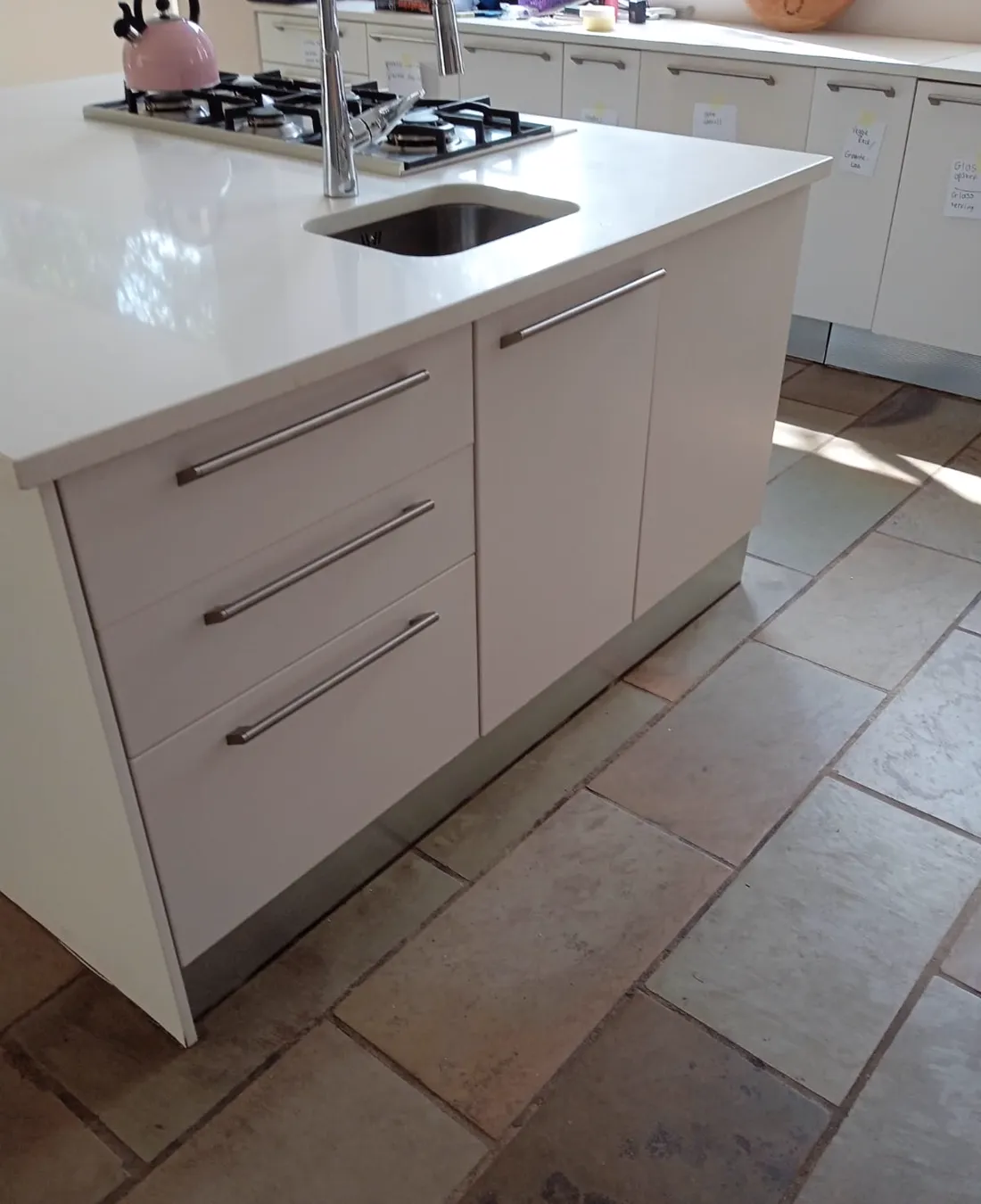 Fitted kitchen island cabinetry with drawers and sink